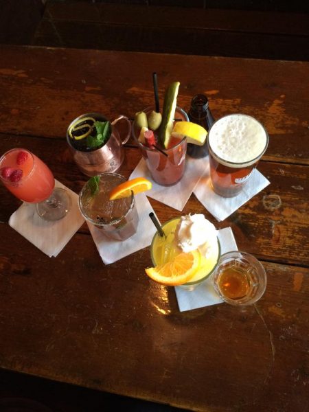 A wooden table with drinks on it.