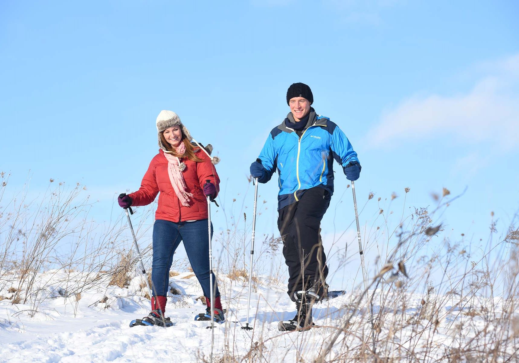 a couple of people riding skis on top of a snow covered slope