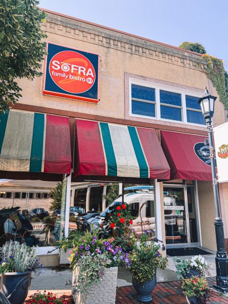 A restaurant with a red and white awning.