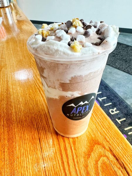 A cup of hot chocolate sitting on a wooden table.