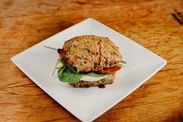 a white plate topped with a sandwich on top of a wooden table.