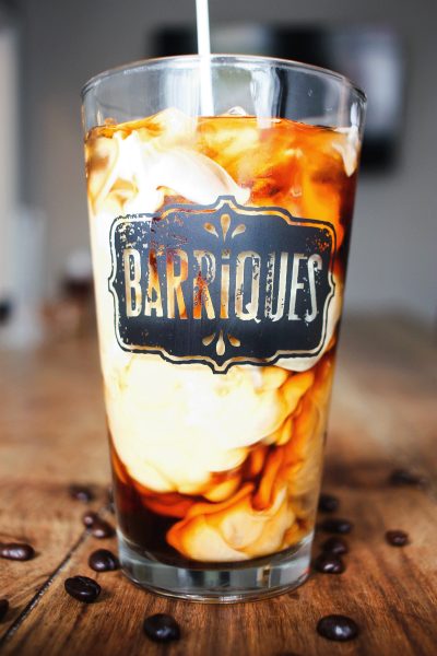 a glass filled with liquid sitting on top of a wooden table.