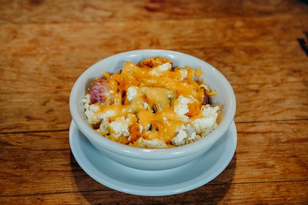 a bowl of food sitting on top of a wooden table.