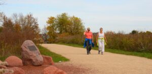 a couple of women walking down a dirt road