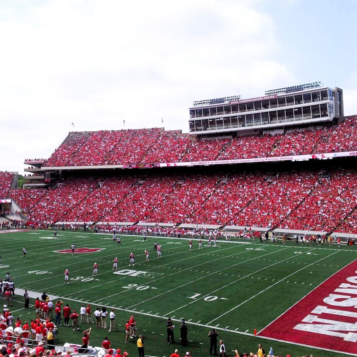 A crowded football stadium bursts with fans in red, a game in progress on the field, and “WISCONSIN” marked in an end zone—a perfect Spring highlight on any sports lover’s itinerary.