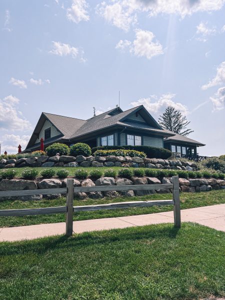 A house on a hill with a fence in front of it.