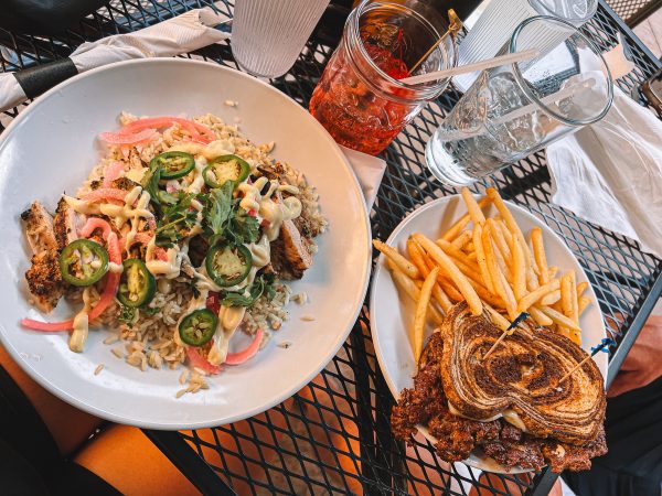 A plate of french fries and a sandwich on a table.