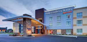 the front of a hotel with a parking lot