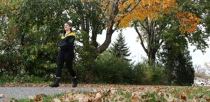 a woman in a black and yellow jacket is walking