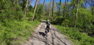 a man riding a bike down a dirt road