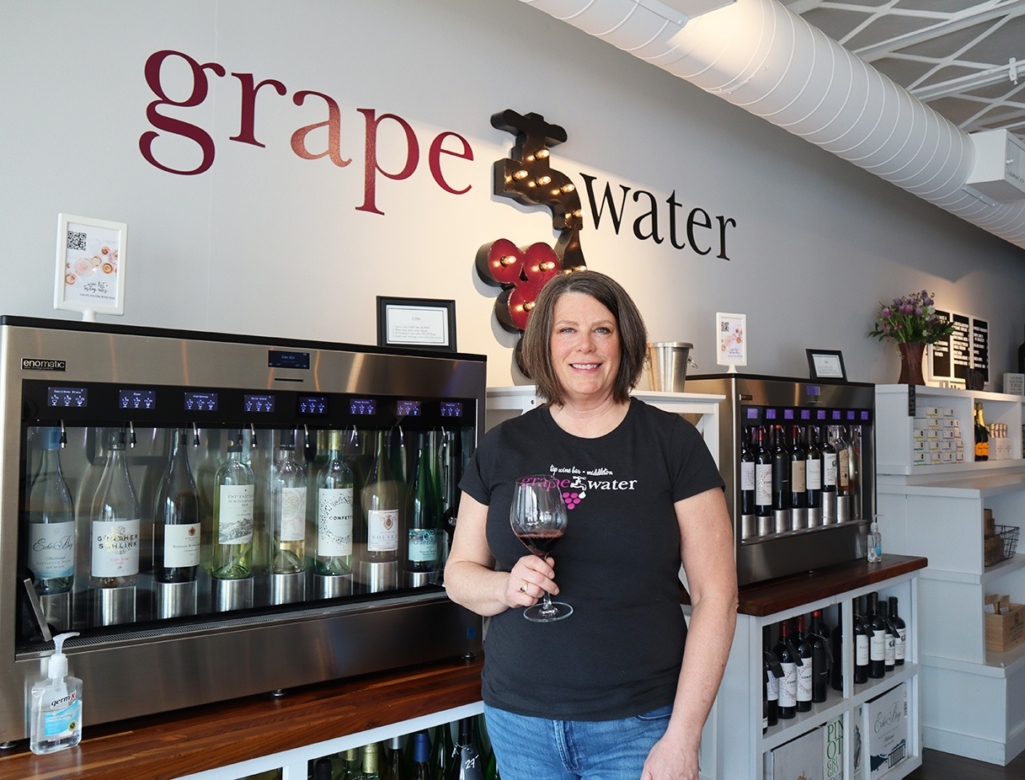 a woman is holding a glass of wine.