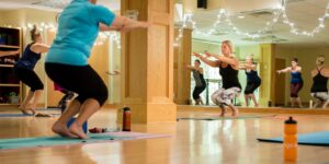 a group of people doing yoga in a room
