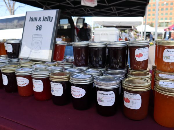 many jars of jam are on a table.
