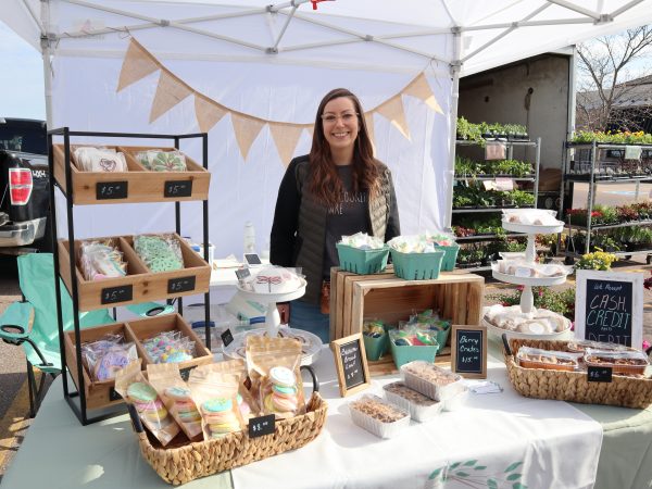 a woman standing in front of a table filled with food.
