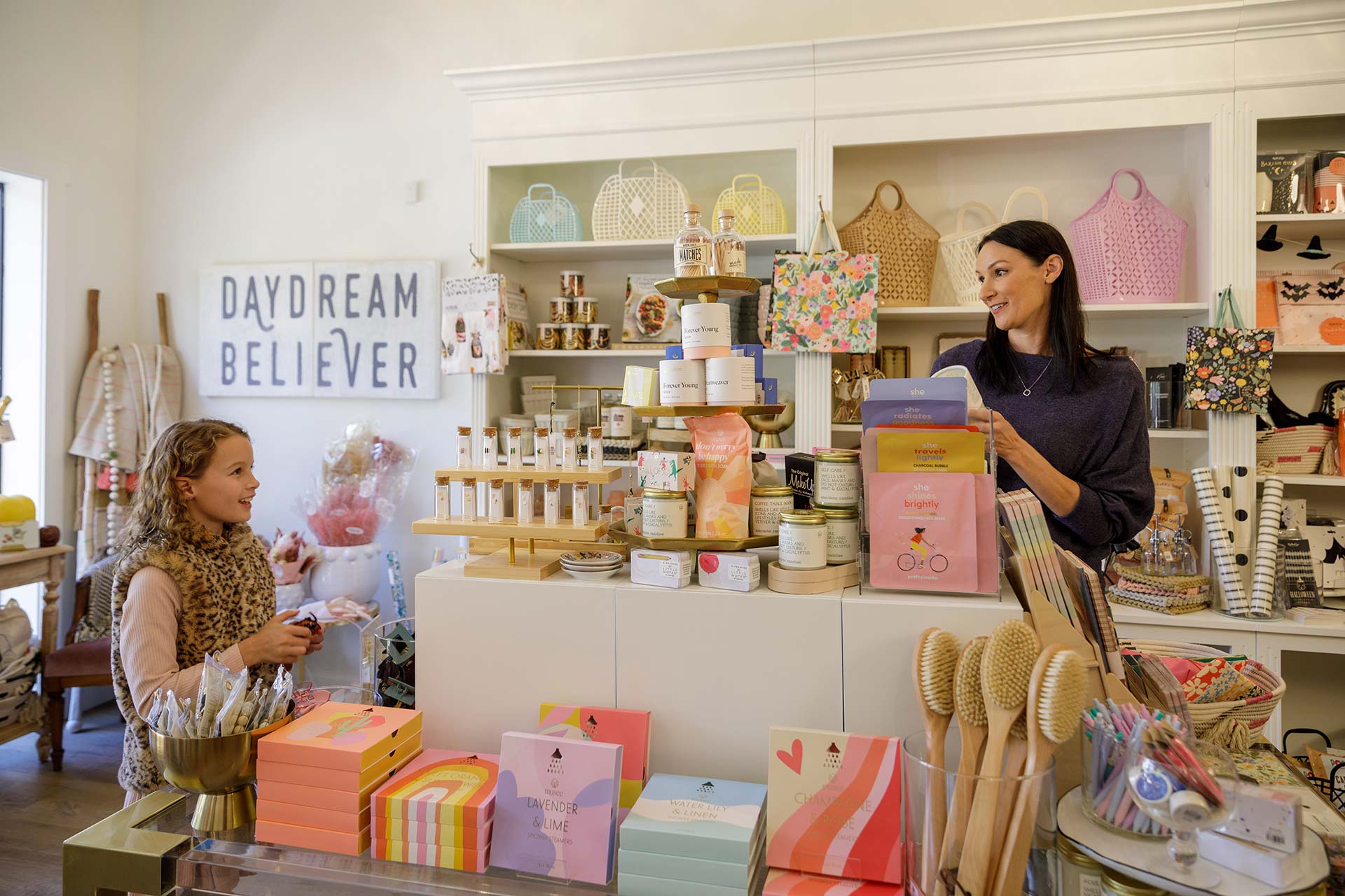 a woman is talking to a little girl in a store