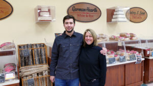 a man and a woman standing in front of a bakery
