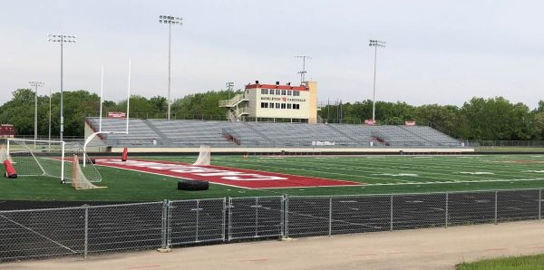 a football field with a field goal and a building in the background.