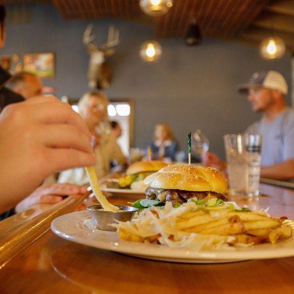A person eating a burger and fries at a restaurant.