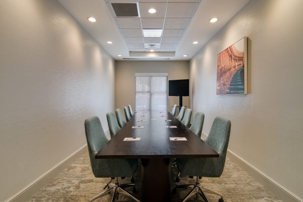 A conference room with a long table and chairs.
