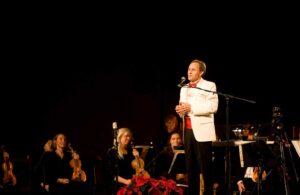 a man standing in front of a microphone on top of a stage