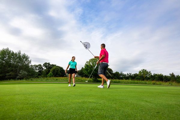 a man and a woman playing a game of golf