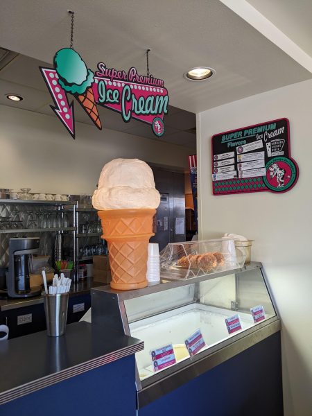 An ice cream shop with a counter and a sign.