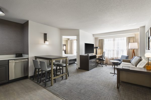 A hotel room with a kitchen and living room.