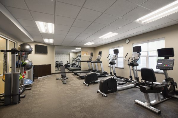 A gym room with a variety of exercise equipment.