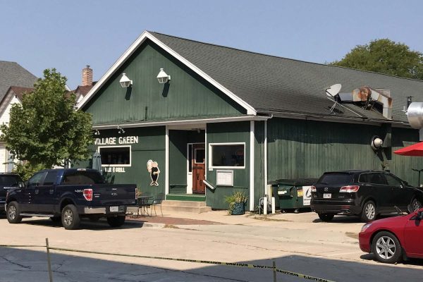 a green building with cars parked in front of it