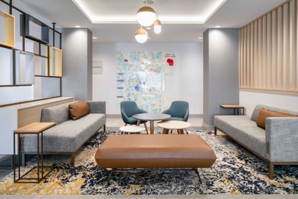 The lobby of a hotel with couches and a coffee table.